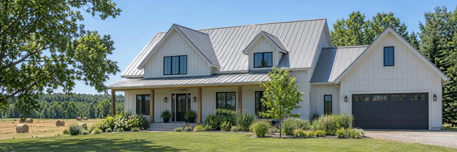 A light grey standing seam metal roof on an Ontario farmhouse in summer sun