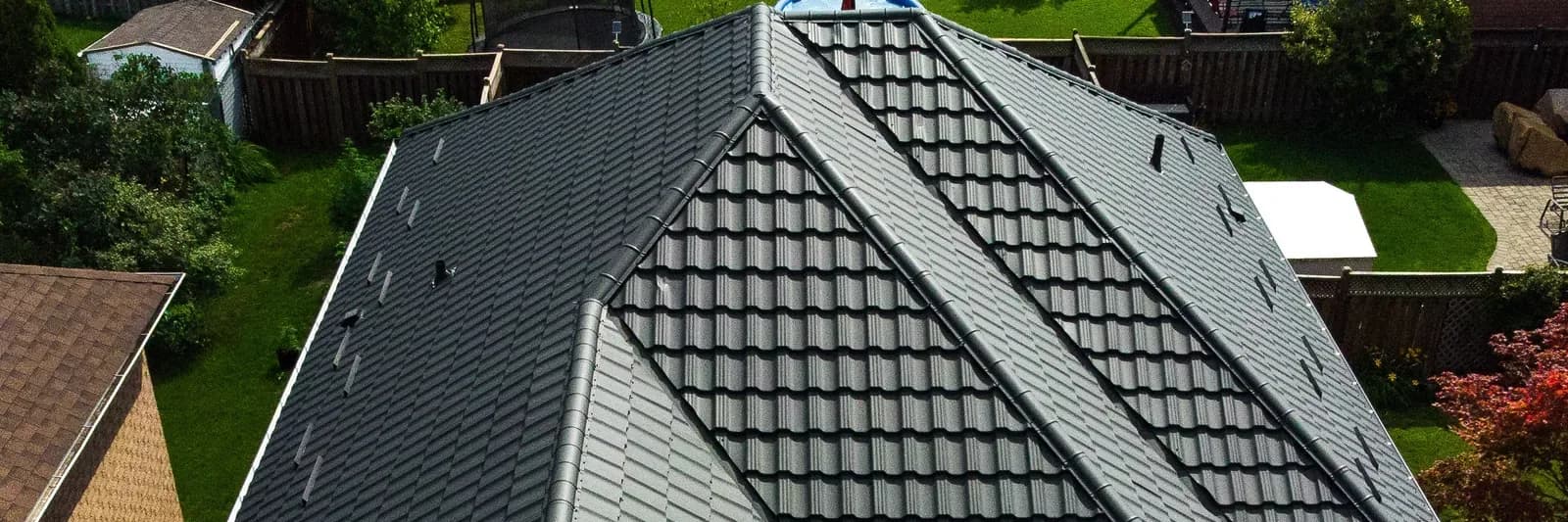 A completed metal roof above a landscaped Ontario garden