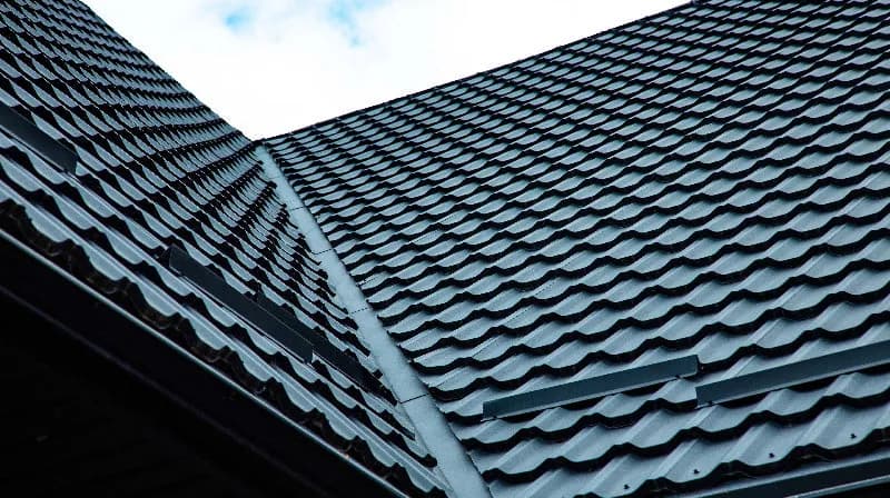 Intersecting slopes of a dark metal tile roof