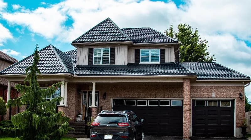 A two-storey home with a dark metal tile roof